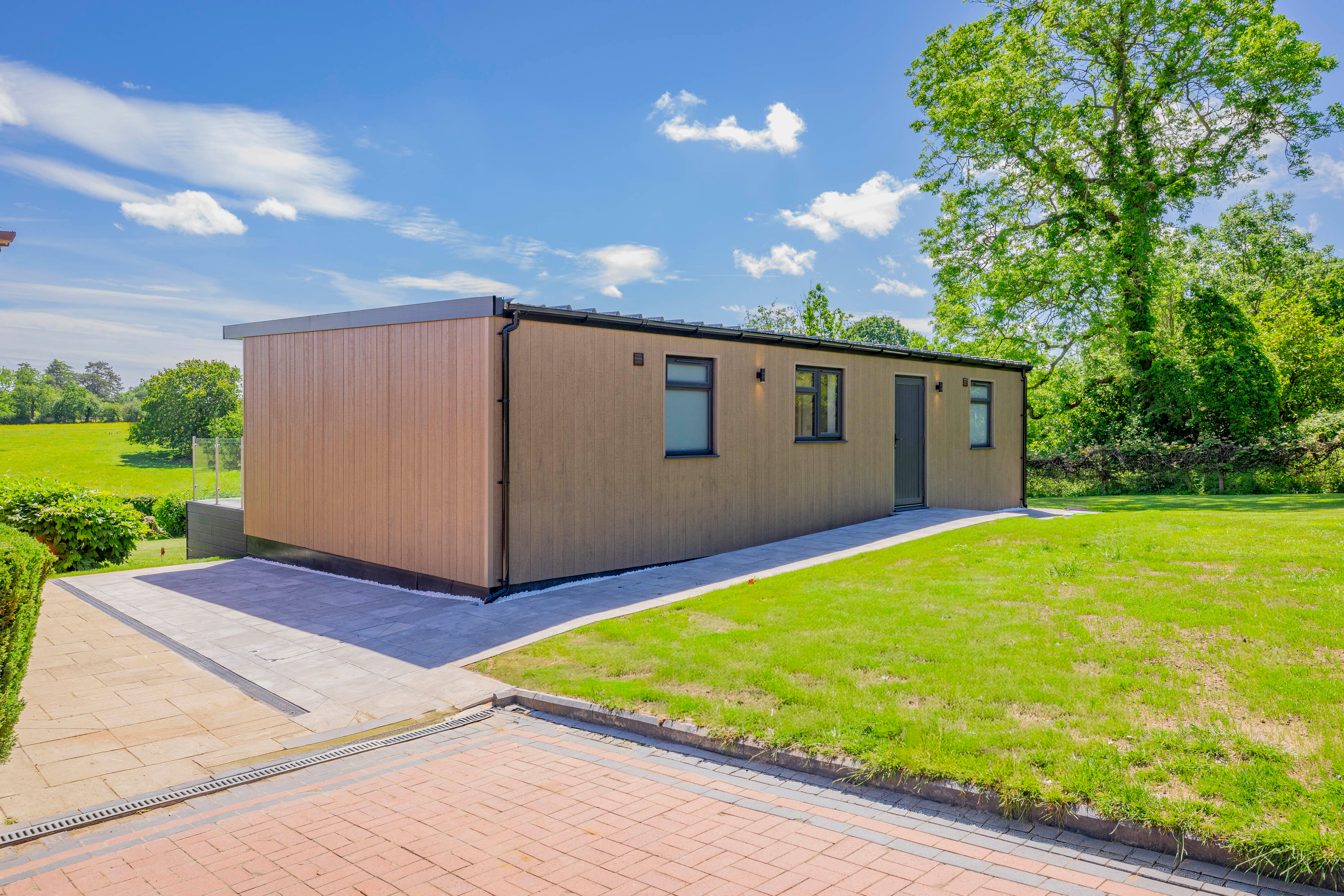Bespoke garden annexe Exterior Design with modern appliances and clean worktops