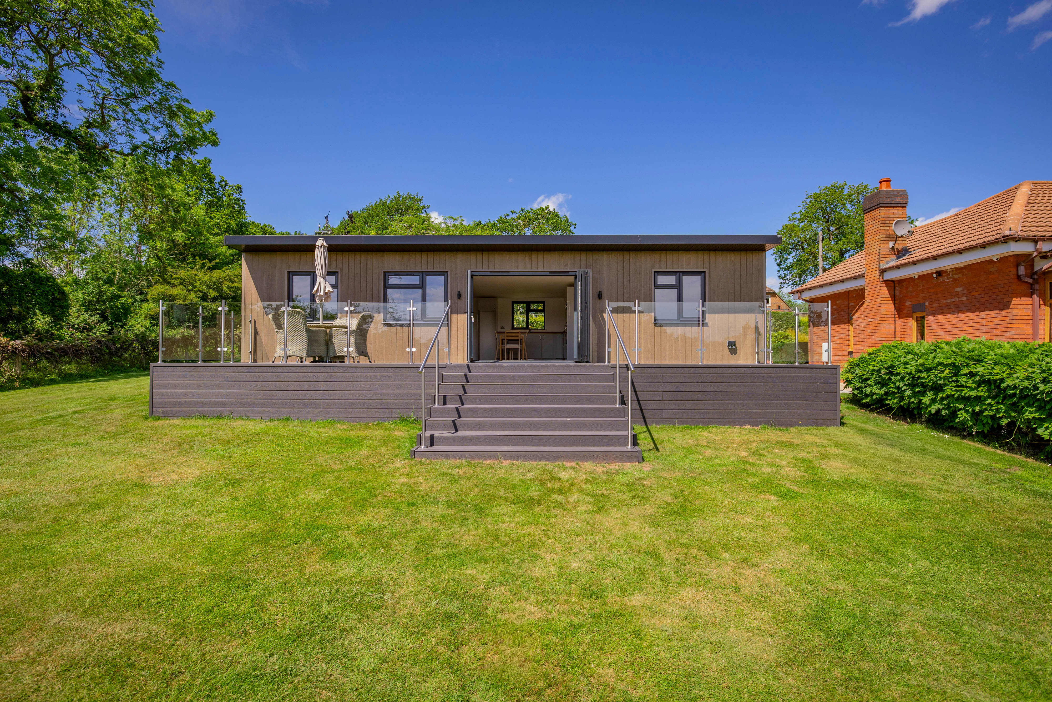 Bespoke garden annexe Exterior Design with modern appliances and clean worktops